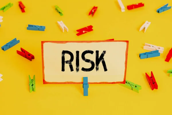 Conceptual hand writing showing Risk. Business photo text Possibility of losing something of value or threat of damage Colored clothespin papers empty reminder yellow floor office. — Stock Photo, Image