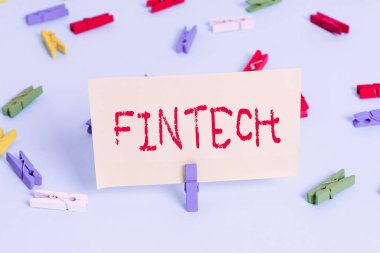 Fintech 'i gösteren kavramsal el yazısı. İş fotoğraflarında bilgisayar programları ve finansal hizmetleri destekleyen diğer teknolojiler. Renkli çamaşır tokası boş hatırlatıcı mavi katlı ofis..