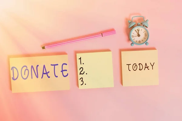 Word writing text Donate. Business concept for give money or goods for good cause for example to charity or showing Three multicolor blank notepads alarm clock marker colored background.