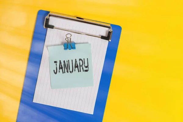 Texto de escritura de palabras Enero. Concepto de negocio para el primer mes del año y considerado el segundo mes de invierno Slim portapapeles celebración de hoja de papel en blanco carpeta de notas de color de fondo . — Foto de Stock