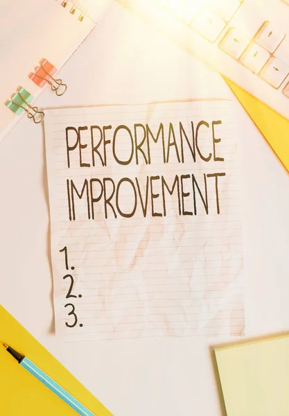 Writing note showing Performance Improvement. Business photo showcasing Measure and Modify the Output to increase efficiency Colored paper different sizes binder clip sheets white desk empty space.