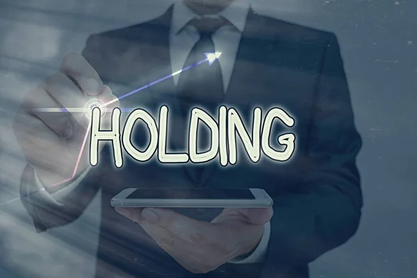 Conceptual hand writing showing Holding. Business photo text stocks property and other financial assets in someone s is possession. — Stock Photo, Image