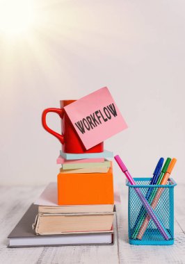 Workflow 'u gösteren not yazılıyor. Bir görev Kupasını tamamlamak için gereken bir dizi faaliyet ya da prosedür serisi iş fotoğrafı. Kare kutu kalemler metal tutucu ahşap masa üzerine dizilmiş not defterleri..