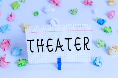 Sinema 'yı gösteren mesaj işareti. Kavramsal fotoğraf oluşturma ya da oyun ve dramatik performansların yer aldığı açık alan Renkli buruşmuş kağıtlar boş hatırlatıcı beyaz zemin çamaşır mandalı.