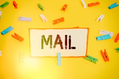 Posta gösteren kavramsal el yazısı. Posta sistemi vasıtasıyla gönderilen ya da teslim edilen iş fotoğrafı metinleri ya da paket Renkli çamaşır iğnesi kağıtları boş hatırlatma sarı zemin ofisi.