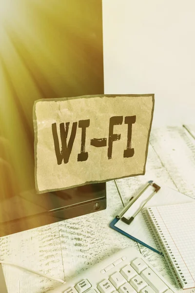 Kelime yazma metni Wi Fi. Radyo teknolojileri için iş kavramı genellikle kablosuz yerel ağ ağı Not kağıdı için kullanılan klavye ve durağan yakınında siyah bilgisayar ekranına bantlanmış.