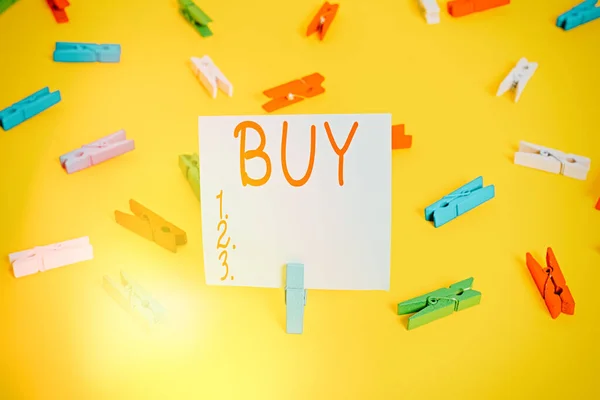 Word writing text Buy. Business concept for to get something by paying money for it Acquire possession or ownership Colored clothespin papers empty reminder yellow floor background office. — Stock Photo, Image
