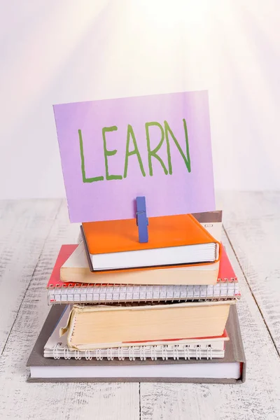 Text sign showing Learn. Conceptual photo acquire knowledge of or skill in something by study or experience pile stacked books notebook pin clothespin colored reminder white wooden. — Stock Photo, Image