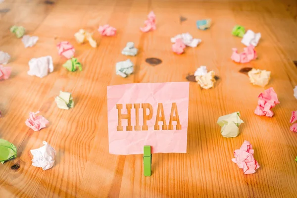 Teksten met Hipaa erop. Conceptuele foto Acroniem staat voor Health Insurance Portability Verantwoording Gekleurde verkreukelde papieren lege herinnering houten vloer achtergrond wasknijper. — Stockfoto