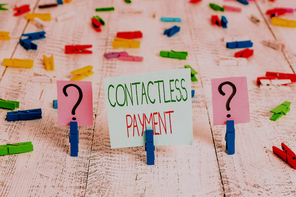 Text sign showing Contactless Payment. Conceptual photo use near field communication for making secure payments Scribbled and crumbling sheet with paper clips placed on the wooden table.