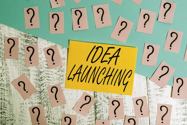 Conceptual hand writing showing Idea Launching. Business photo text to begin something new such as a plan or business venture Crumbling papers with thick cardboard on the wooden table.