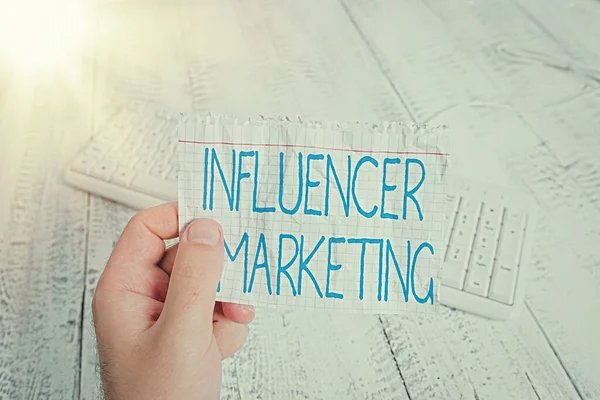 Escritura manual conceptual que muestra Influencer Marketing. Texto de la foto del negocio Endorser que influyen en potenciales clientes objetivo Hombre sosteniendo recordatorio colorido piso de madera de papel en forma cuadrada . — Foto de Stock