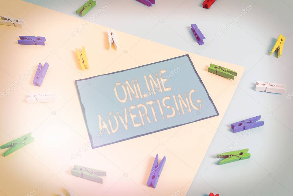 Text sign showing Online Advertising. Conceptual photo Internet Web Marketing to Promote Products and Services Colored clothespin paper empty reminder yellow blue floor background office.