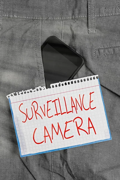 Writing note showing Surveillance Camera. Business photo showcasing Closed Circuit Television transmit signal on monitors Smartphone device inside trousers front pocket note paper. — Stock Photo, Image