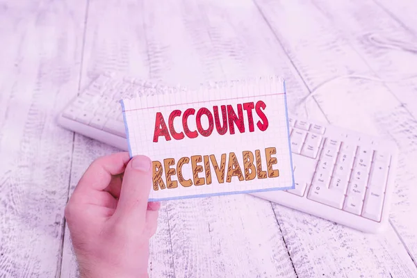 Signo de texto que muestra cuentas por cobrar. Foto conceptual Reclamación Legal de Pago Dinero Owed to by Debtors man holding colorful reminder square shaped paper white keyboard wood floor . — Foto de Stock