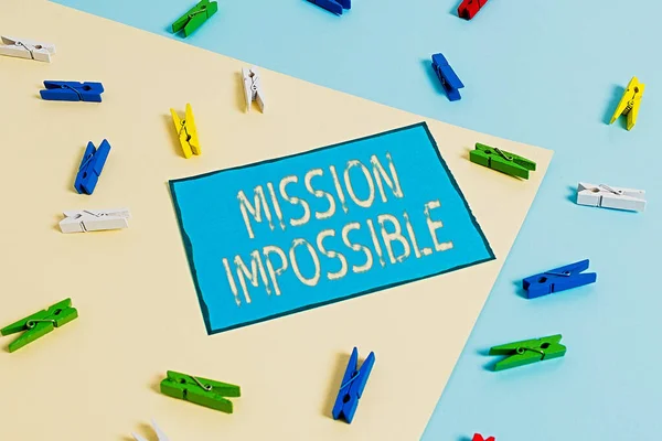 Text sign showing Mission Impossible. Conceptual photo Difficult Dangerous Assignment Isolated Unimaginable Task Colored clothespin paper empty reminder yellow blue floor background office. — Stock Photo, Image