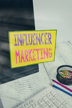 El yazısı, metin yazma, pazarlama. Potansiyel Hedef Müşterileri etkileyen Endorser kavramı. Klavye ve durağanlık yakınlarındaki siyah bilgisayar ekranına yapıştırılmış not kağıdı..