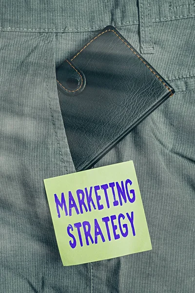 Написание заметки, показывающей маркетинговую стратегию. Схема демонстрации бизнес-фото о том, как выложить продукты Бизнес Маленький бумажник в переднем кармане брюк рядом с нотной бумагой . — стоковое фото