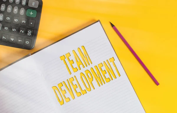 Conceptual hand writing showing Team Development. Business photo text learn why and how small groups change over time with graphs Open hard cover notebook pencil marker calculator color background. — Stock Photo, Image