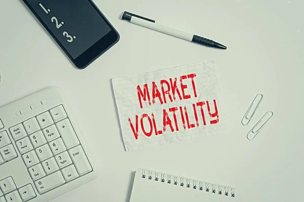 Writing note showing Market Volatility. Business photo showcasing Underlying securities prices fluctuates Stability status Flat lay above computer mobile phone pencil and copy space note paper.