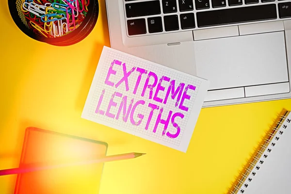 Signo de texto que muestra longitudes extremas. Foto conceptual Haga un gran esfuerzo o extremo para hacer algo mejor Laptop lápiz clips hoja contenedor espiral cuaderno de color de fondo . — Foto de Stock