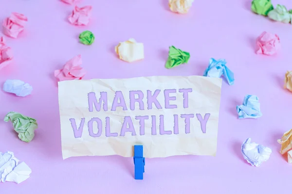 Writing note showing Market Volatility. Business photo showcasing Underlying securities prices fluctuates Stability status Colored crumpled papers empty reminder pink floor background clothespin.