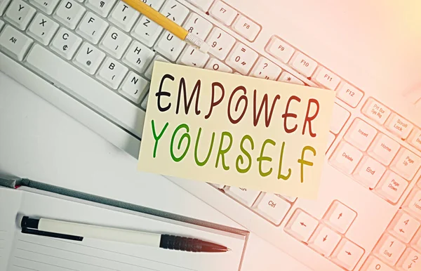 Handschriftliches Textschreiben Empower Yourself. Konzept, das bedeutet, die Kontrolle über das Leben zu übernehmen, Ziele zu setzen, positive Entscheidungen zu treffen Weiße Tastatur mit Notizbuch und Clips auf weißem Hintergrund. — Stockfoto