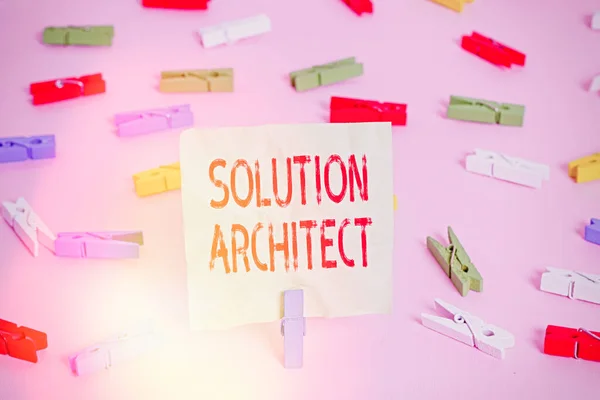 Conceptual hand writing showing Solution Architect. Business photo text Design applications or services within an organization Colored clothespin papers empty reminder pink floor office pin.