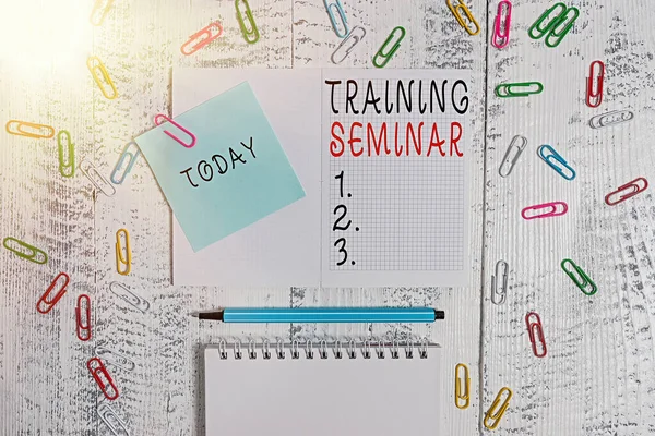 Handwriting text writing Training Seminar. Concept meaning Academic instruction Formal presentation of a research Squared spiral notepad clips note highlighter lying old wooden background.