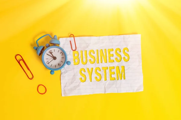 Writing note showing Business System. Business photo showcasing A method of analyzing the information of organizations Metal alarm clock blank crushed note rubber band colored background. — Stock Photo, Image