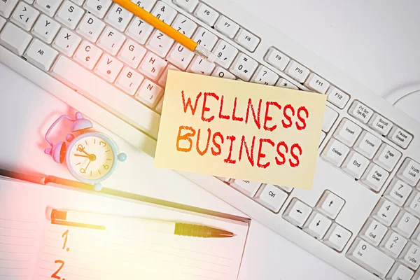 Text skylt som visar Wellness Business. Konceptfoto Professionell satsning med fokus på hälsa sinne och kropp Platt låg ovanför tom not papper på st tangentbord pennor och klocka. — Stockfoto