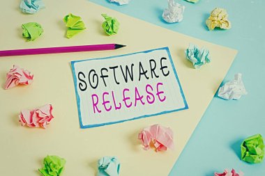 El yazısı yazımı yazılım sürümü. Geliştirme aşamalarının toplamı ve program için olgunluk anlamına gelen konsept Renkli buruşmuş kağıtlar boş hatırlatıcı mavi arka plan çamaşır mandalı.