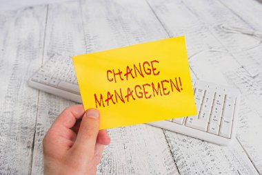 Değişim Yönetimini gösteren kavramsal el yazısı. Bir organizasyonda liderlik değişimini gösteren iş fotoğrafı. Yeni Politikalar Adamı elinde renkli hatırlatıcı kare şeklindeki kağıt ahşap zemin tutuyor..