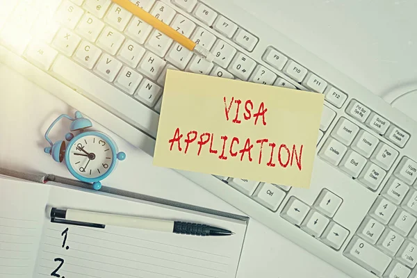 Text sign showing Visa Application. Conceptual photo Form to ask permission travel or live in another country Flat lay above empty note paper on the pc keyboard pencils and clock.