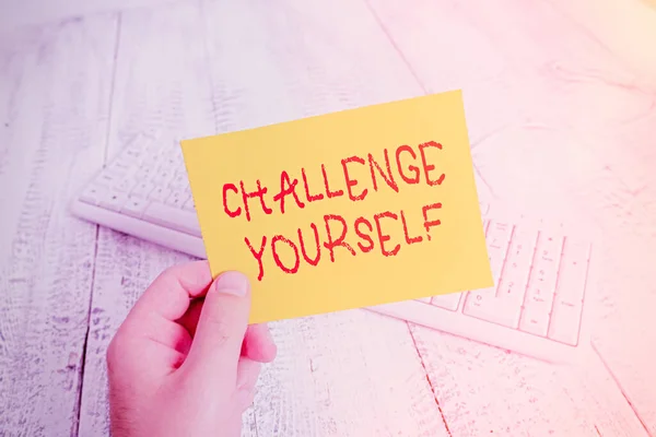 Conceptual hand writing showing Challenge Yourself. Business photo showcasing Setting Higher Standards Aim for the Impossible Man holding colorful reminder square shaped paper wood floor. — Stock Photo, Image