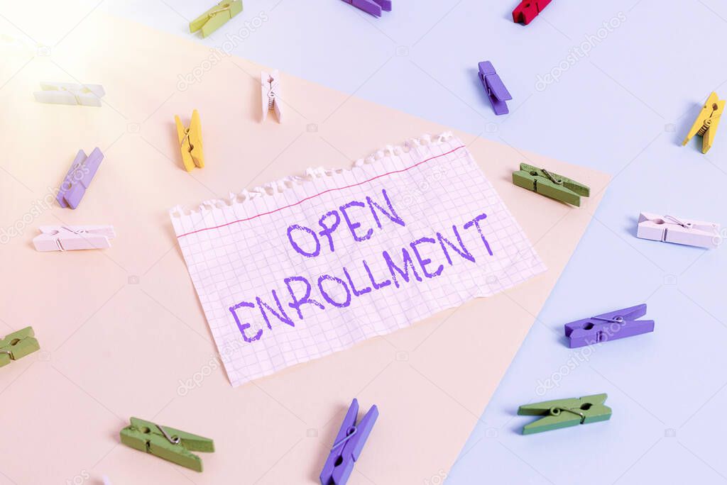 Word writing text Open Enrollment. Business concept for The yearly period when showing can enroll an insurance Colored clothespin paper empty reminder yellow blue floor background office.