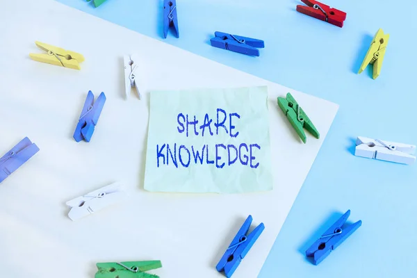 Writing note showing Share Knowledge. Business photo showcasing teaching others what I learnt before Giving lectures Colored clothespin paper reminder with yellow blue background.