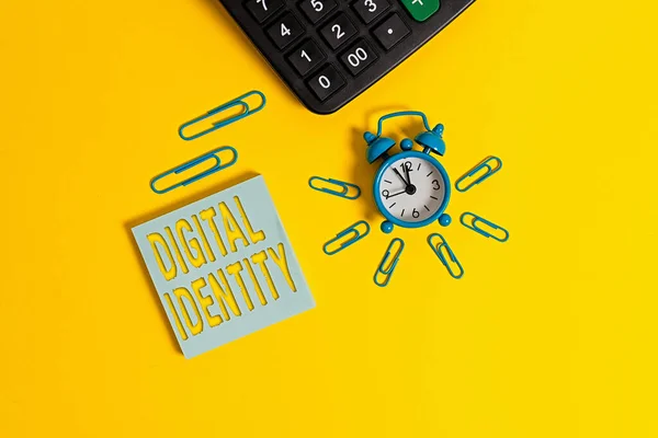 Text sign showing Digital Identity. Conceptual photo information on entity used by computer to represent agent Metal retro alarm clock wakeup clips calculator notepad colored background.