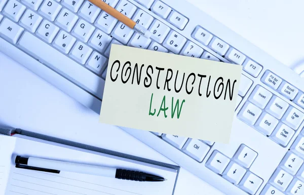 Handwriting text writing Construction Law. Concept meaning deals with matters relating to building and related fields White keyboard with note paper and clips on white background. — Stock Photo, Image