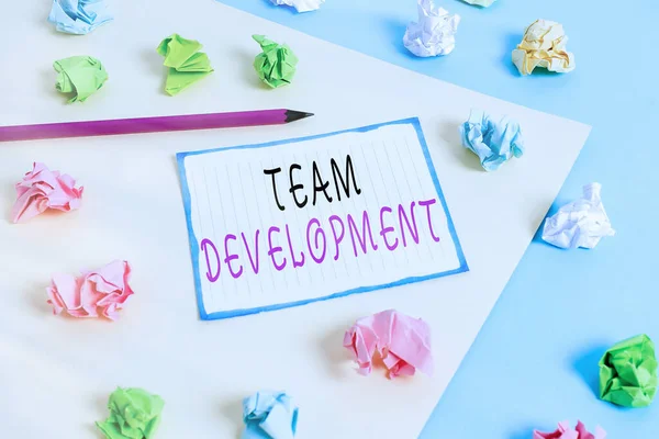 Handwriting text Team Development. Concept meaning learn why and how small groups change over time with graphs Colored crumpled papers empty reminder blue yellow background clothespin. — Stock Photo, Image