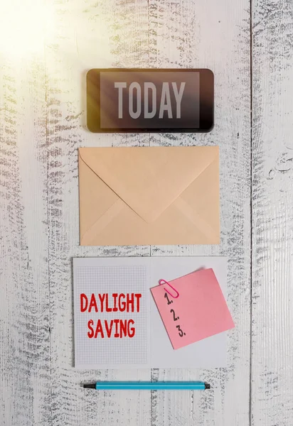 Texto de escritura de palabras Daylight Saving. Concepto de negocio para tecnologías de almacenamiento que se pueden utilizar para proteger los datos Envelop smartphone bloc de notas marcador de clip viejo fondo vintage de madera . —  Fotos de Stock