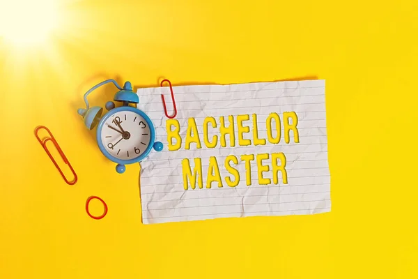 Schreiben Notiz zeigt Bachelor Master. Business photo showcasing Ein fortgeschrittener Abschluss abgeschlossen nach Bachelor s ist Grad Metall Wecker blank zerkleinert Note Gummiband farbigen Hintergrund. — Stockfoto