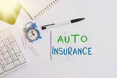 Otomobil Sigortası el yazısı metni. Finansal kayıplara karşı korunma anlamına gelen kavram, bilgisayar cep telefonu saat kalemi üzerinde yatar ve uzay not kağıdını kopyalar..