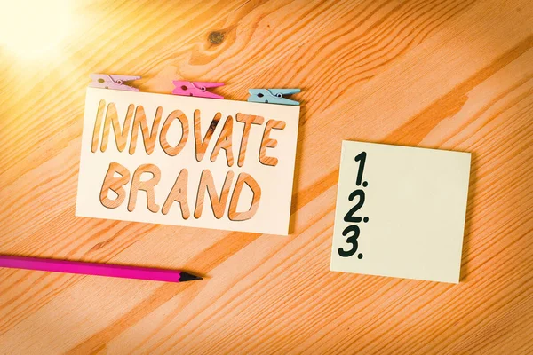 Escritura a mano conceptual que muestra Innovate Brand. Texto de foto de negocios significativo para innovar productos, servicios y más Papeles arrugados de colores Pinza de tela de fondo de piso de madera . — Foto de Stock