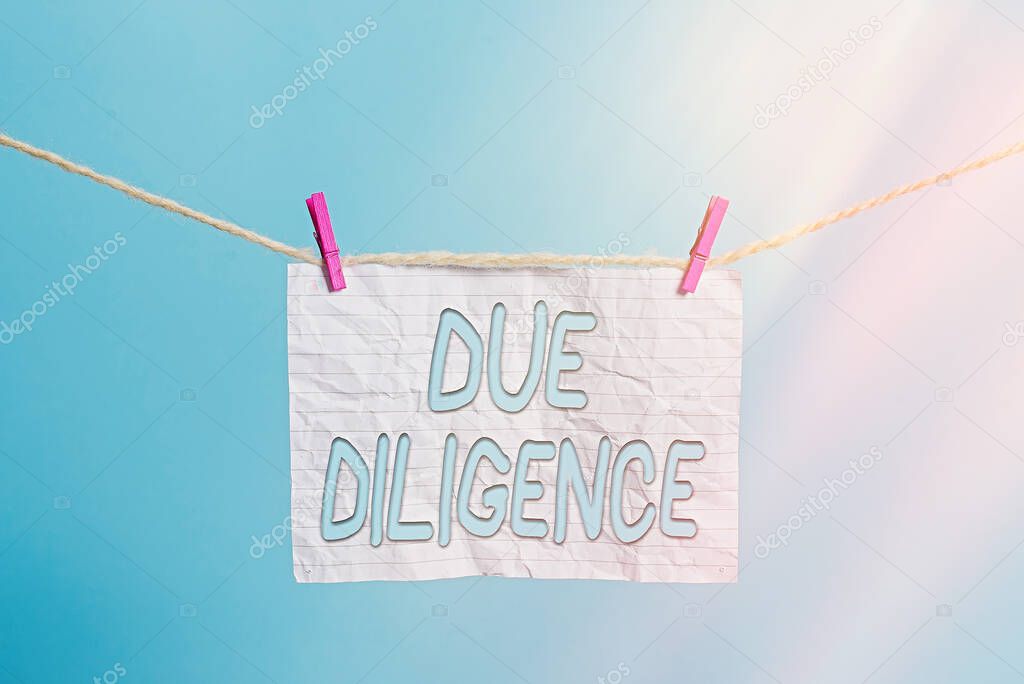 Handwriting text Due Diligence. Concept meaning Comprehensive Appraisal Voluntary Investigation Audit Clothesline clothespin rectangle shaped paper reminder white wood desk.