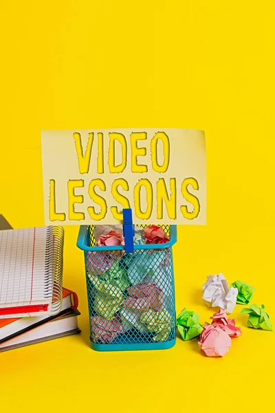 Writing note showing Video Lessons. Business photo showcasing Online Education material for a topic Viewing and learning Trash bin crumpled paper clothespin office supplies yellow.