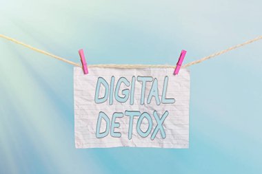 El yazısı metni Dijital Detox. Elektronik Aygıtlardan Kurtlardan Kurtul anlamına gelen kavram Takılı olmayan Çamaşır İpi Çamaşır İpi Dikdörtgeni şekilli kağıt anımsatıcı beyaz ahşap masa.