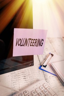 Kelime yazma gönüllülüğü. Klavye ve durağanlık yakınındaki siyah bilgisayar ekranına bantlanmış hiçbir finansal kazanç olmaksızın hizmet sağlama konsepti.