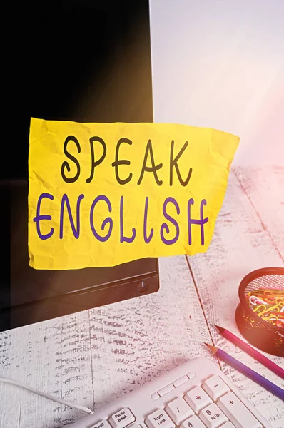 Text sign showing Speak English. Conceptual photo Study another Foreign Language Online Verbal Courses Note paper taped to black computer screen near keyboard and stationary. — Stock Photo, Image