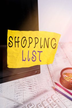 Alış veriş listesini gösteren metin işareti. Klavye ve durağanlık yakınındaki siyah bilgisayar ekranına bantlanmış Not kağıdı almak için Temel Ögeler 'e kavramsal fotoğraf disiplini yaklaşımı.